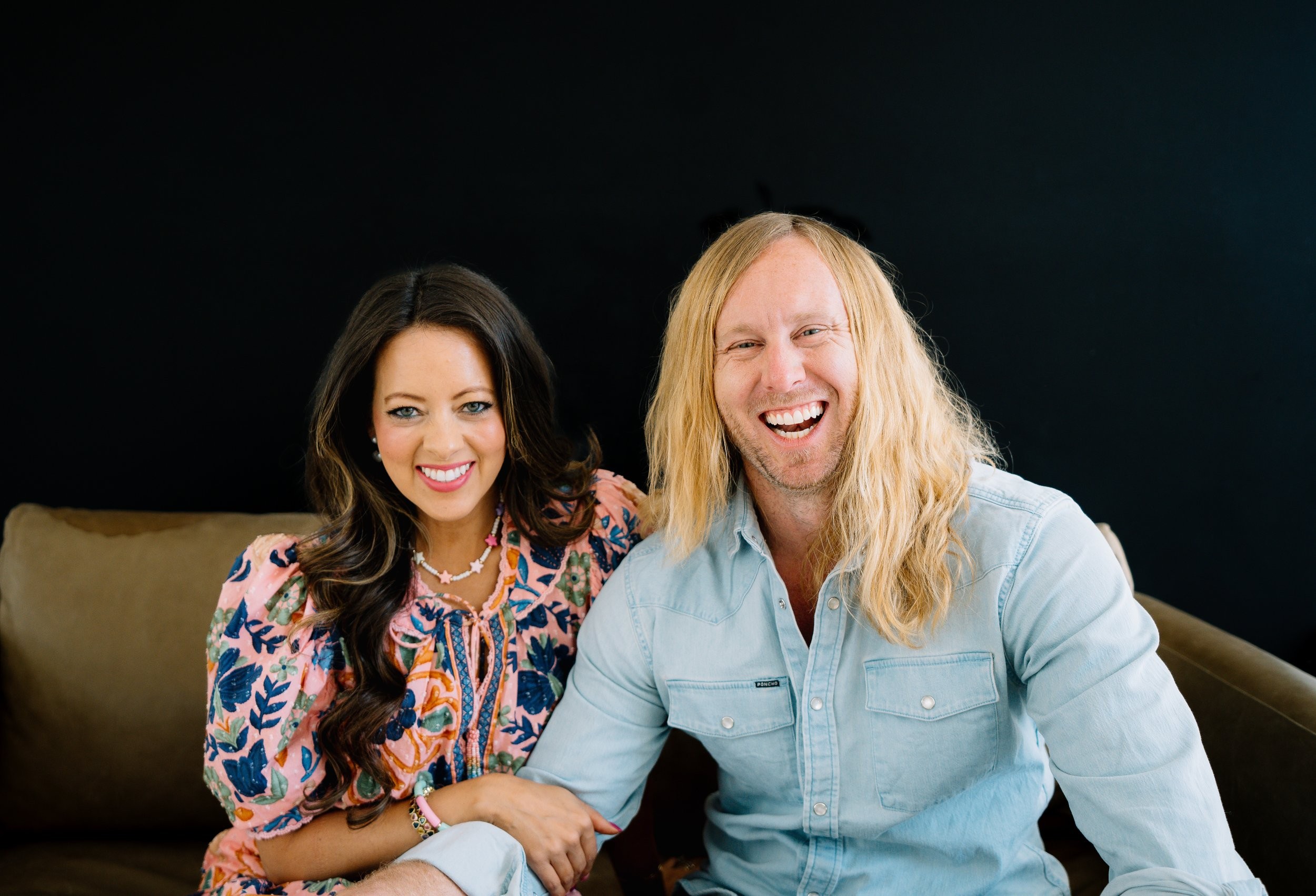Jamey and Melissa Ice laughing together on a sofa