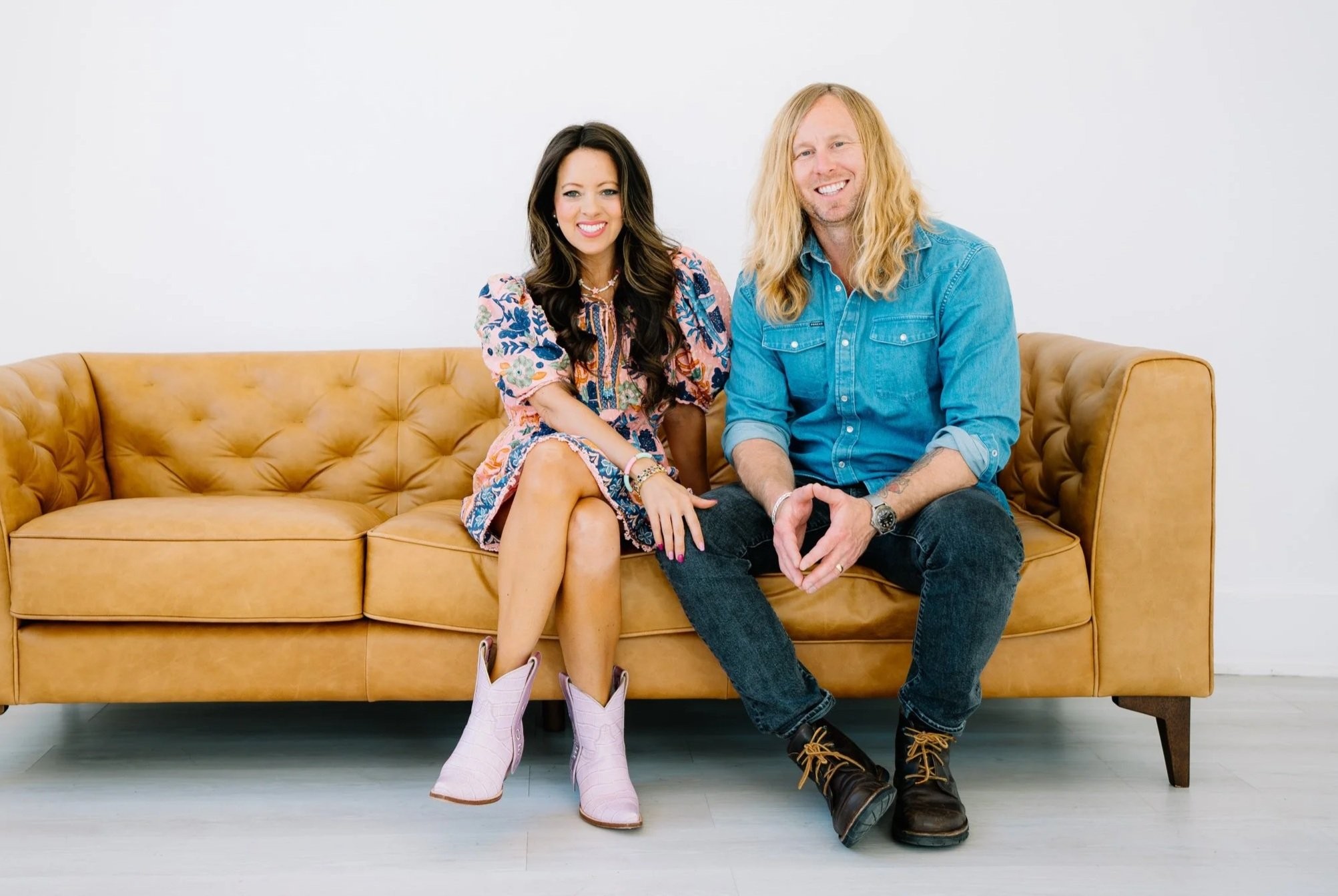 Jamey and Melissa Ice sitting together on a tan leather sofa