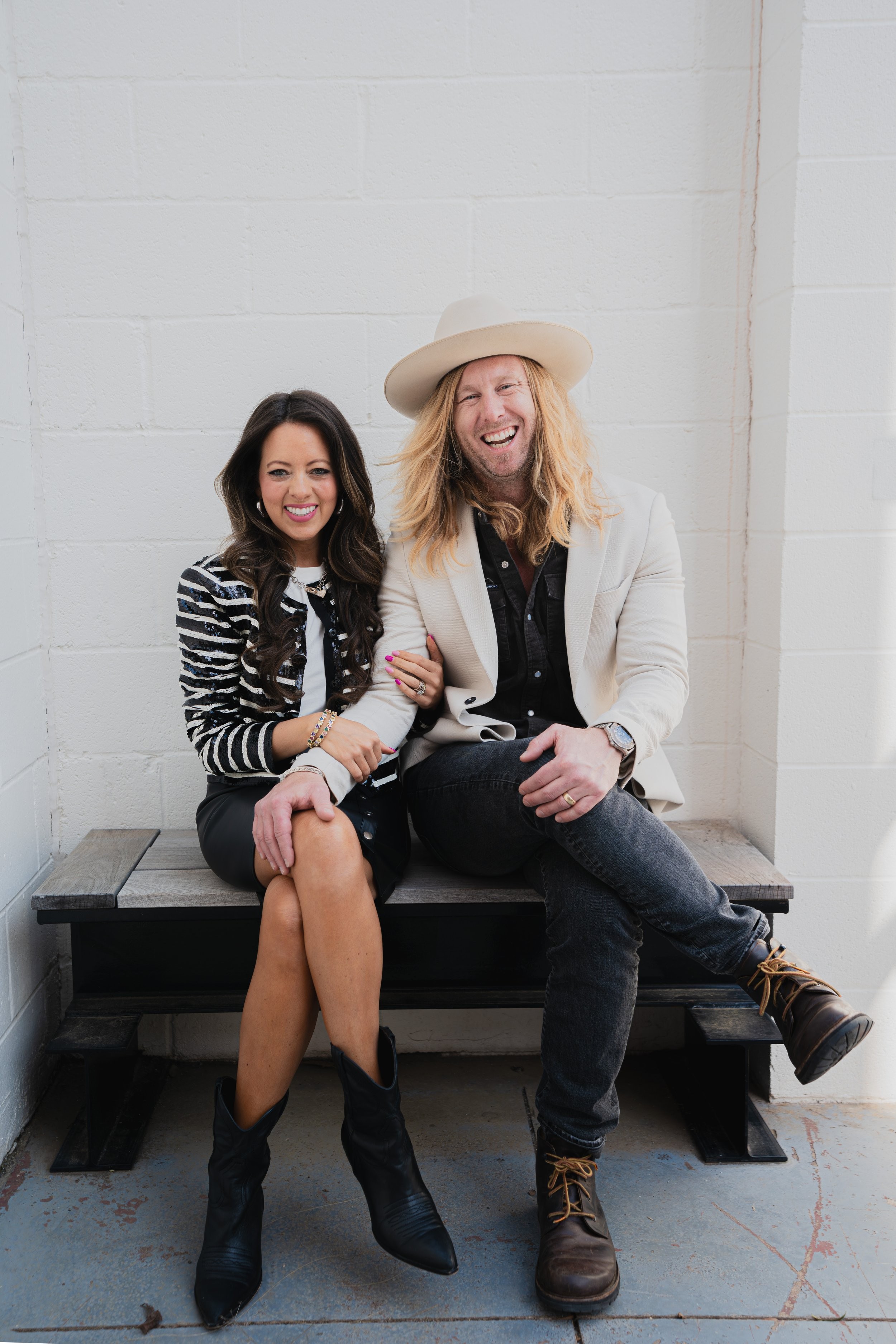 Jamey and Melissa Ice sitting close on a wooden bench, laughing