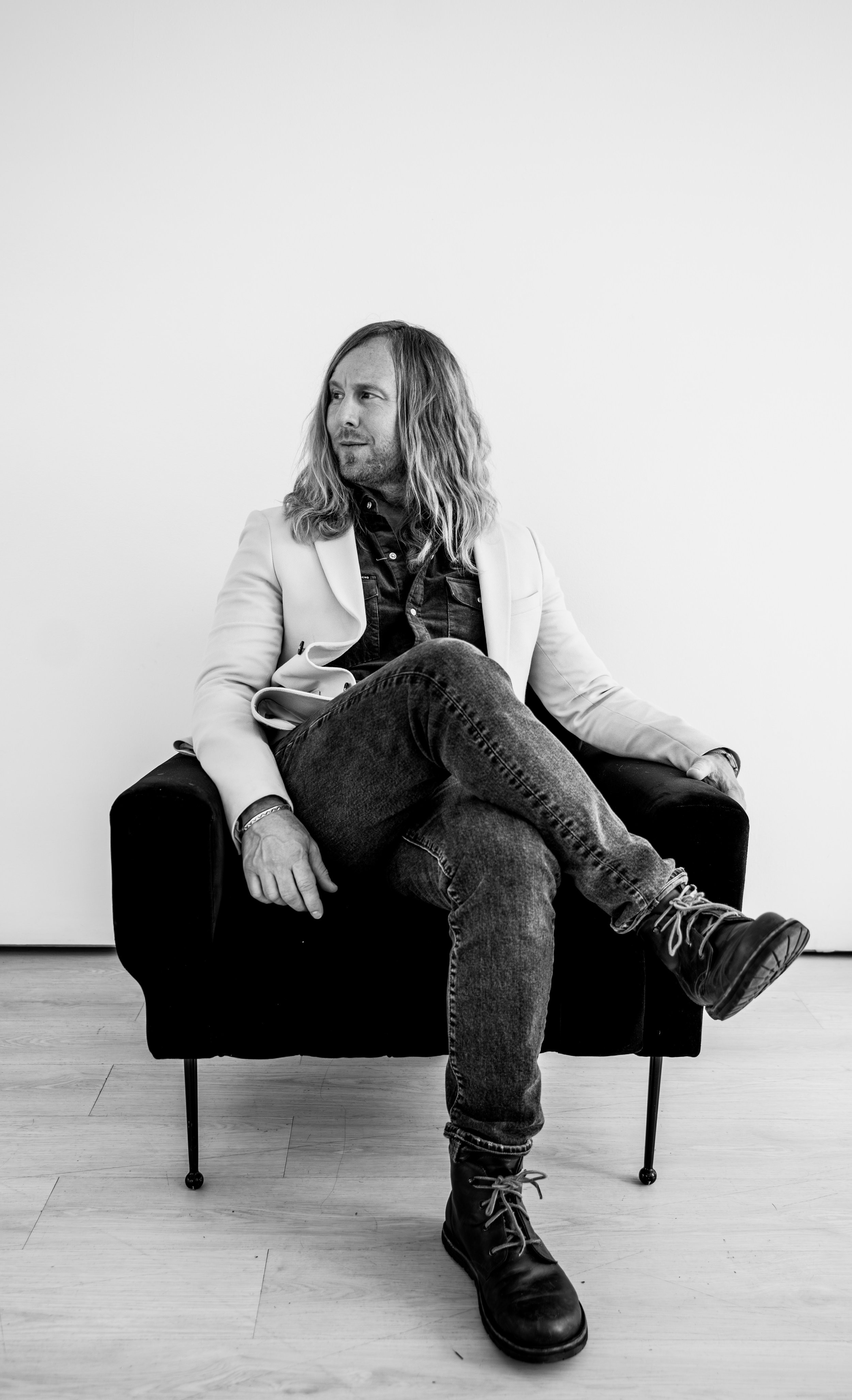 Jamey Ice in a black armchair, in black and white