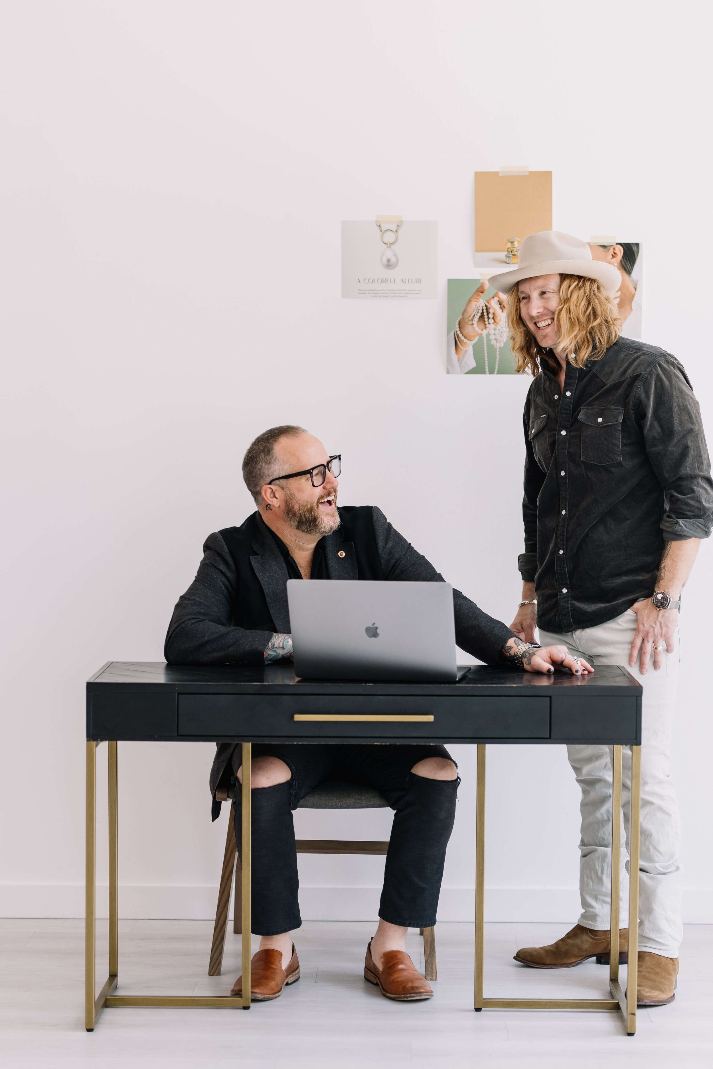 Jamey Ice standing beside a colleague at a desk with an open laptop.