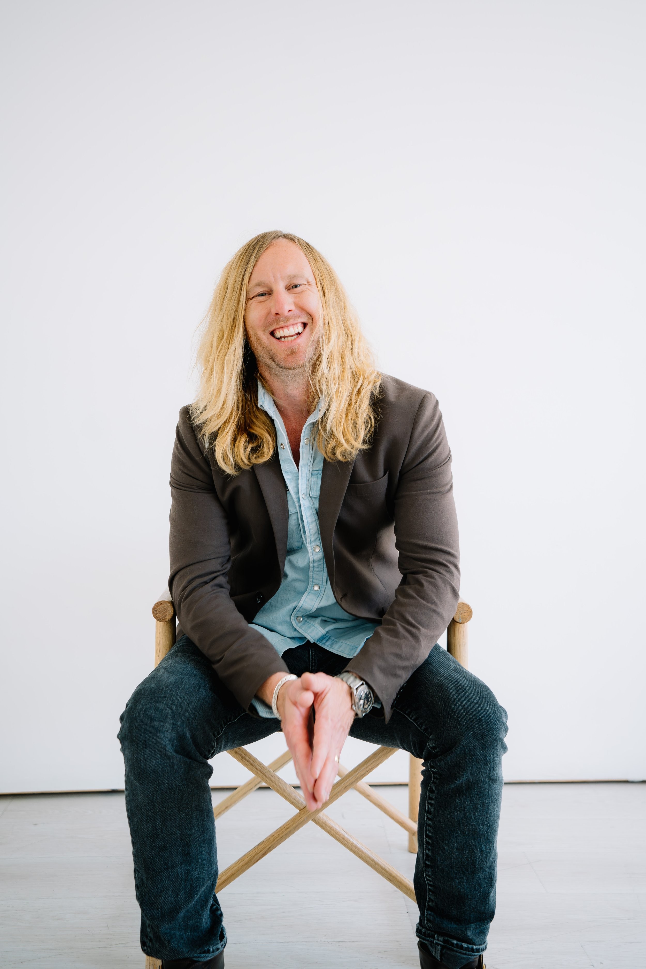 Jamey Ice laughing in a director's chair.