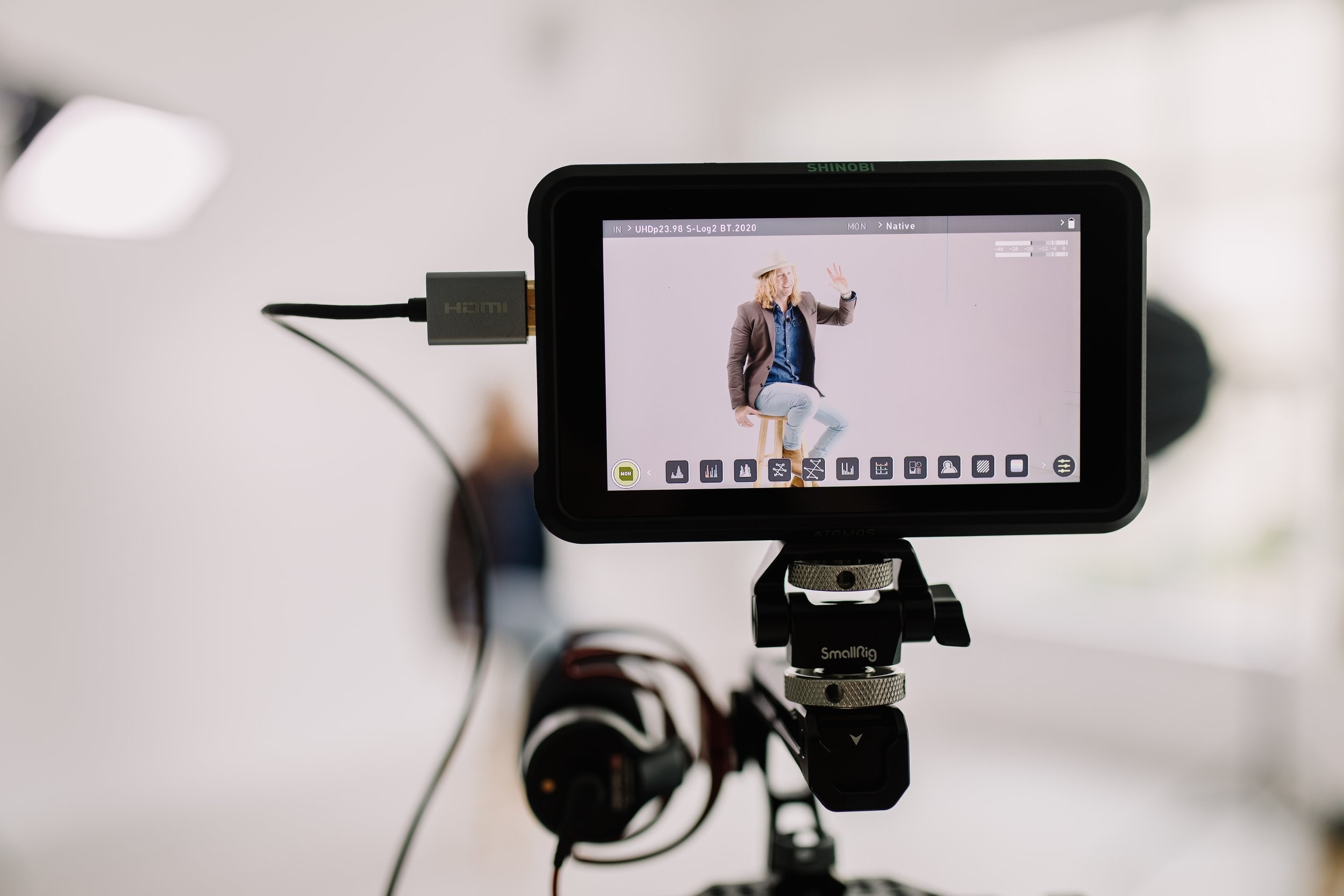 A camera monitor showing Jamey Ice on a stool in the studio behind it.