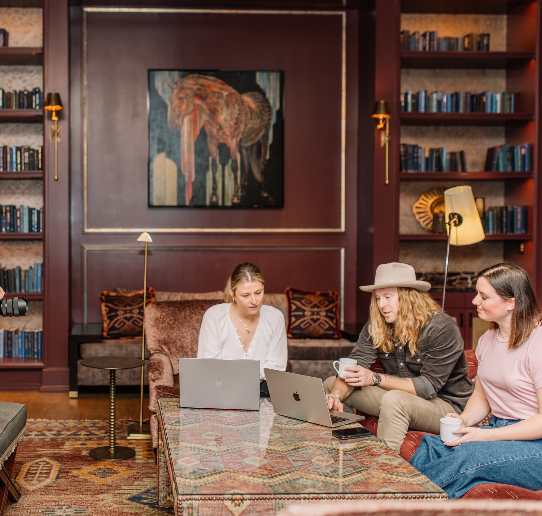 Jamey Ice with two of his team at open laptops in a library room